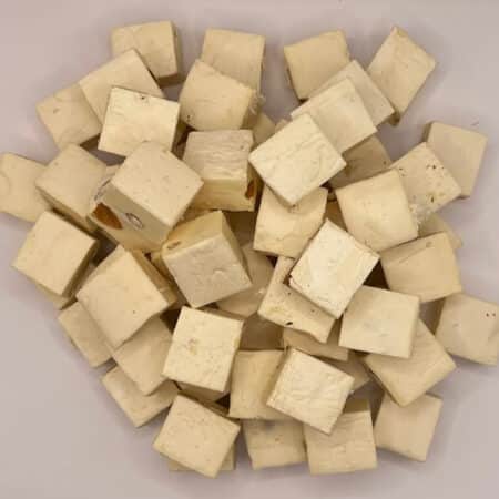 Lonka Nougat mit Mandeln: Ansicht von oben auf ein geöffnetes Stück und eine Tüte mit der Aufschrift „Lonka Soft Nougat Almond“.